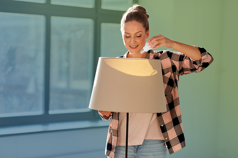 Woman changing light bulb